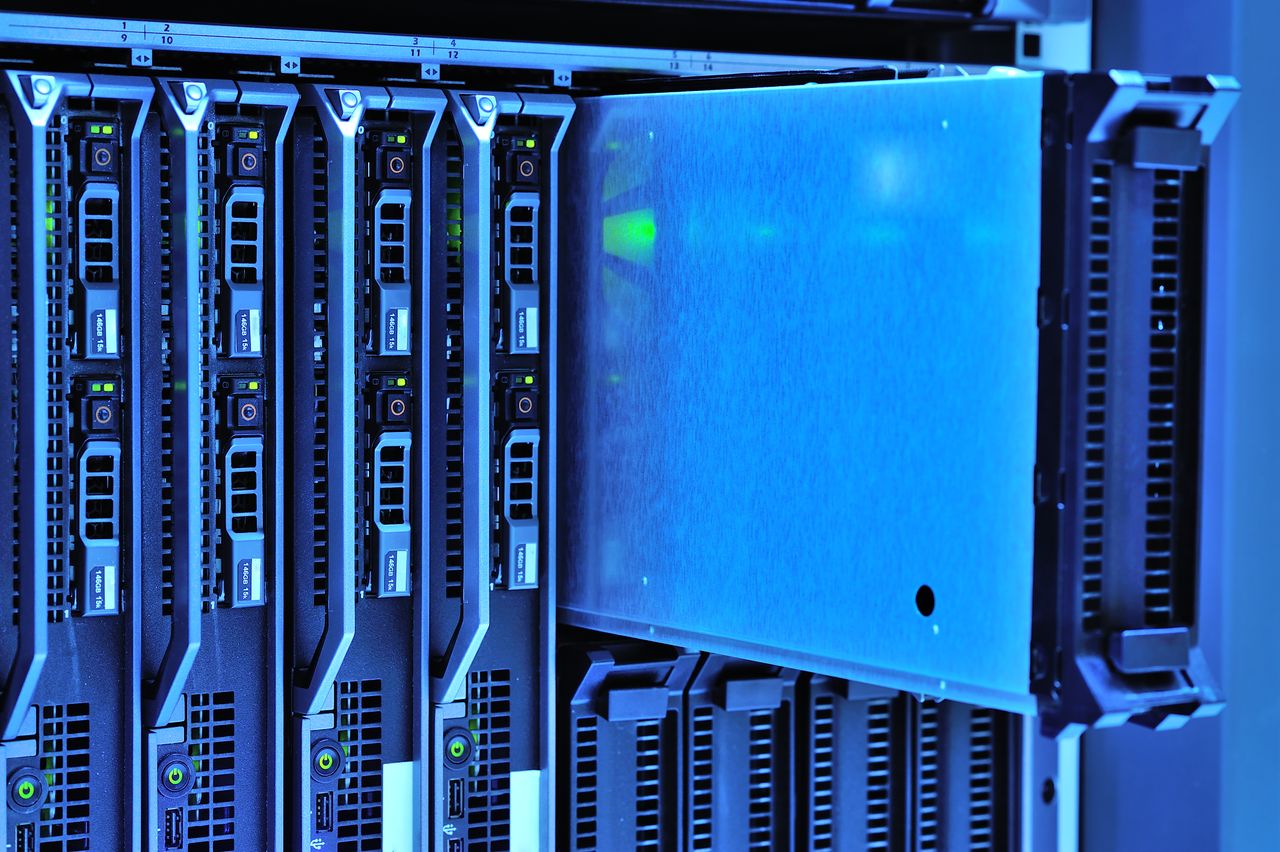 gallery-3 Detailed view of server racks with glowing lights in a data center environment.